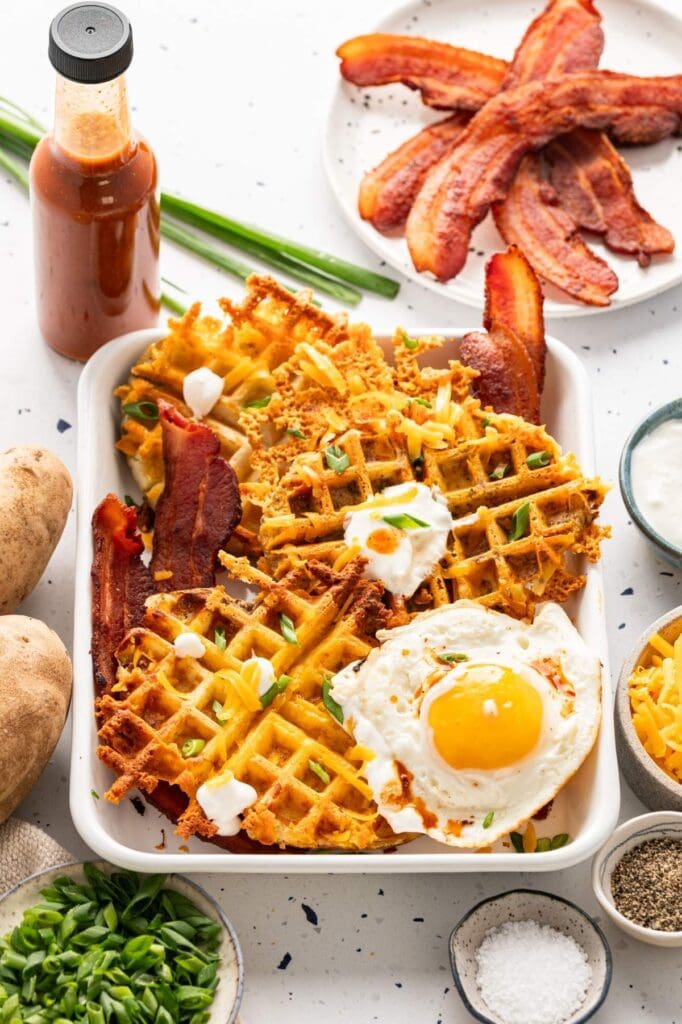 Loaded cheesy potato waffles with bacon and egg.