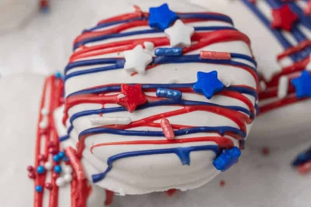 Close-up of white chocolate Oreo with red, white, and blue sprinkles.