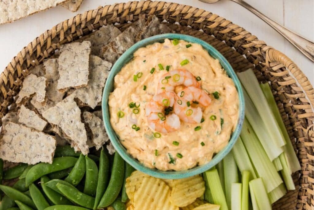 Creamy shrimp dip with crackers, celery, and vegetables.