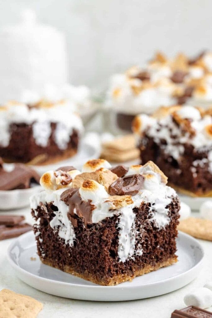 Slice of S'mores poke cake on a plate.