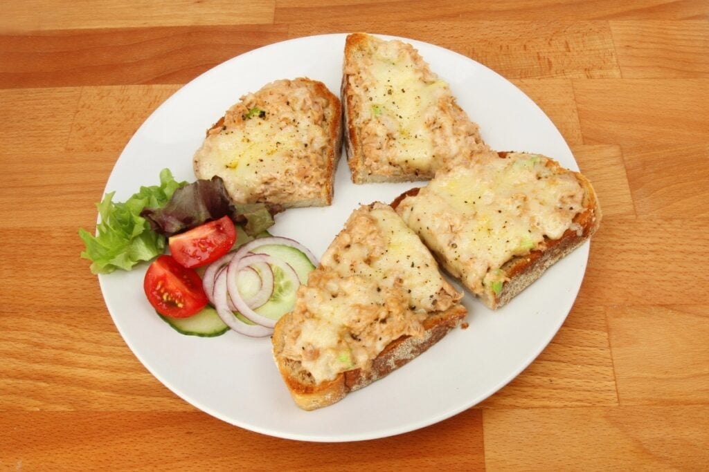 Tuna melt on toast on a plate.
