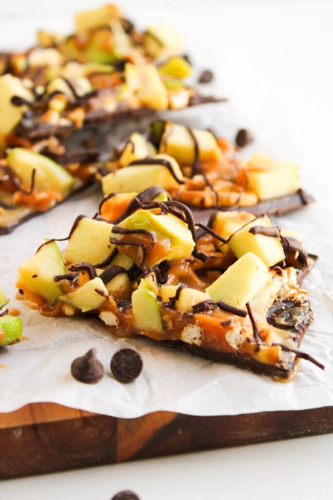 Caramel apple bark topped with apples, caramel, and chocolate drizzle.