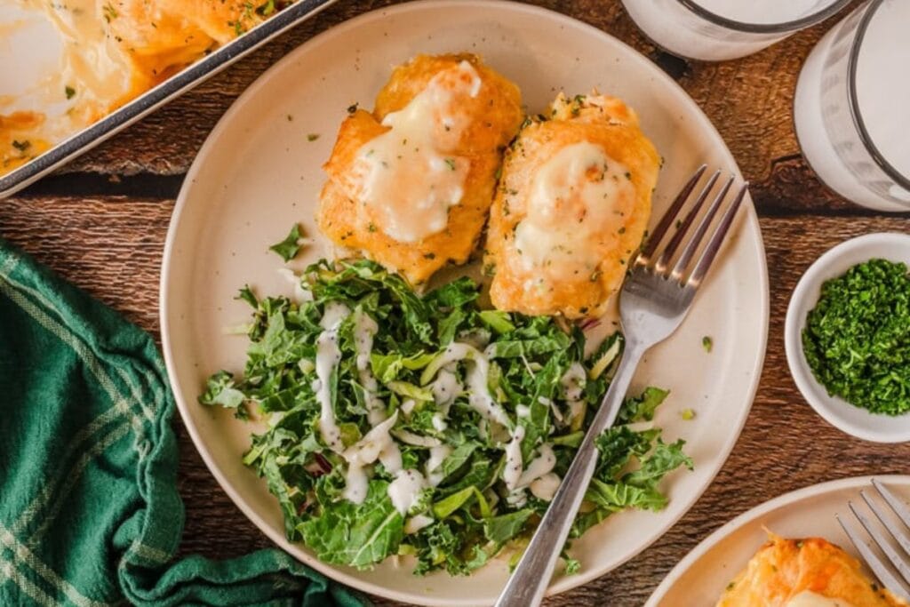 Cheesy chicken crescent rolls served on a plate with salad.