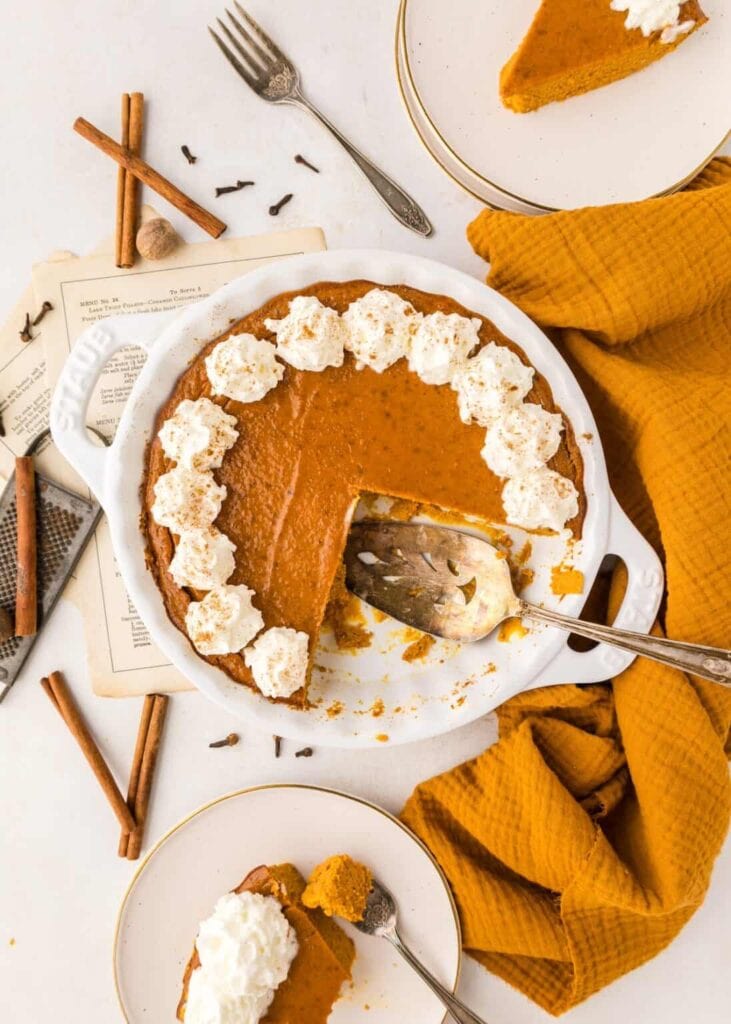 Crustless pumpkin pie with whipped cream in a pie dish.