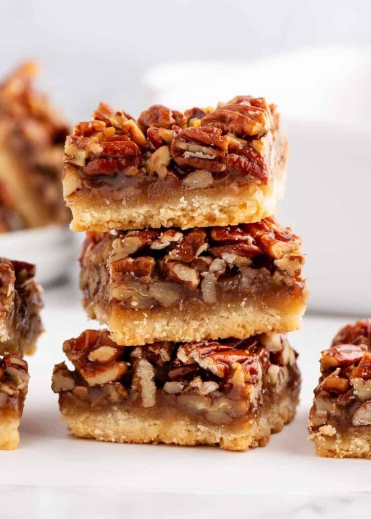 Stacked pecan pie bars with gooey nut filling and flaky crust.