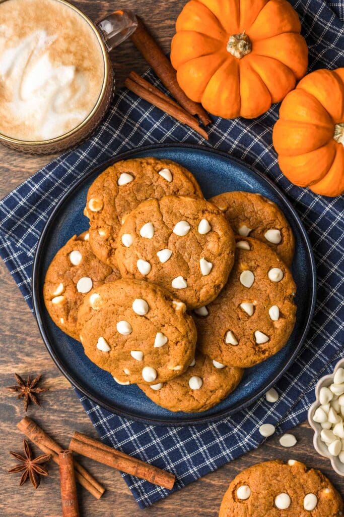 Pumpkin cookies with white chocolate chips on a plate.