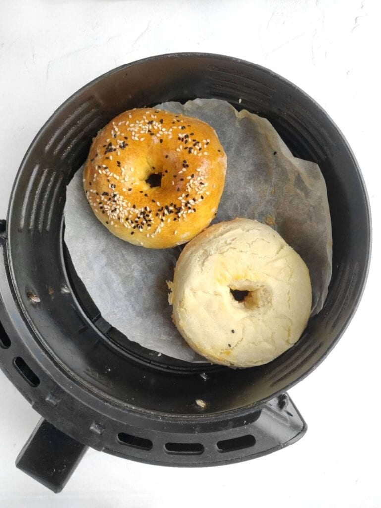 Bagels in an air fryer basket.