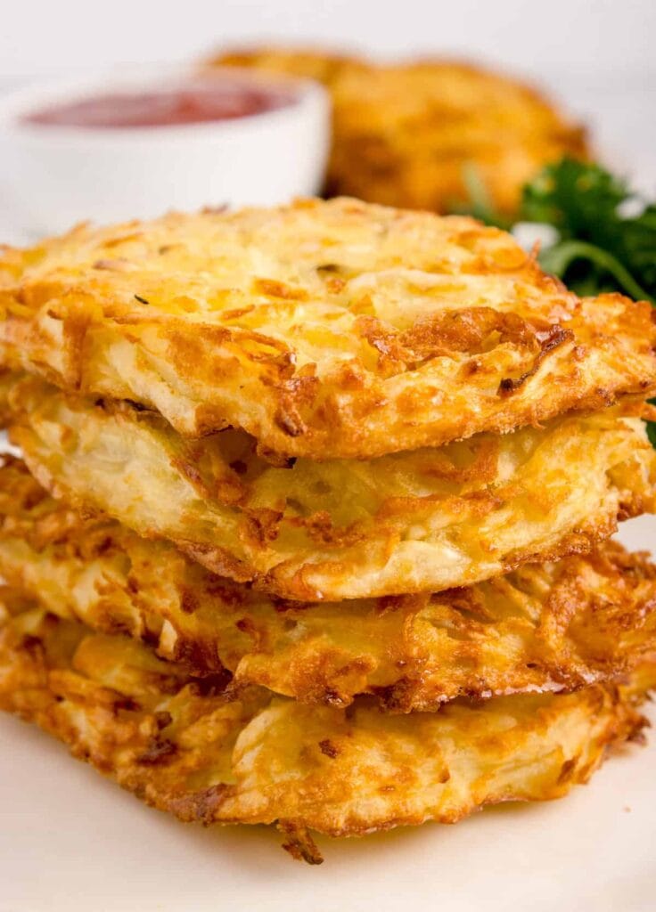 Air Fryer Hash Browns stacked on a plate.