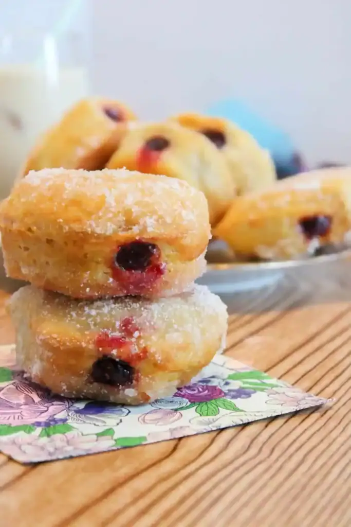 Air Fryer Jelly Donuts coated in sugar and filled with berry jelly.