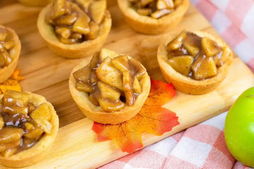 Apple crisp cookie cups on a wooden board.