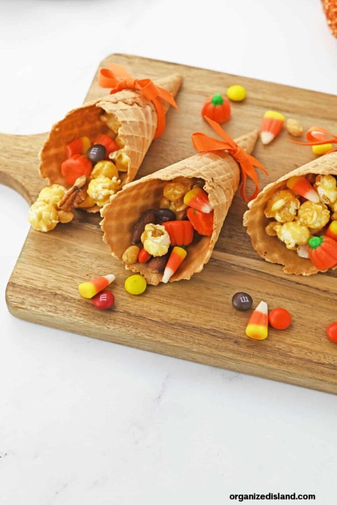 Candy cornucopias on a wooden board.