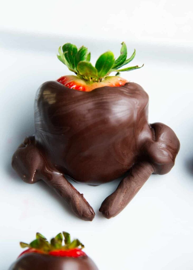 Chocolate-covered strawberry turkeys on a plate.