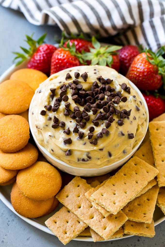 Cookie dough dip with strawberries, cookies, and graham crackers.