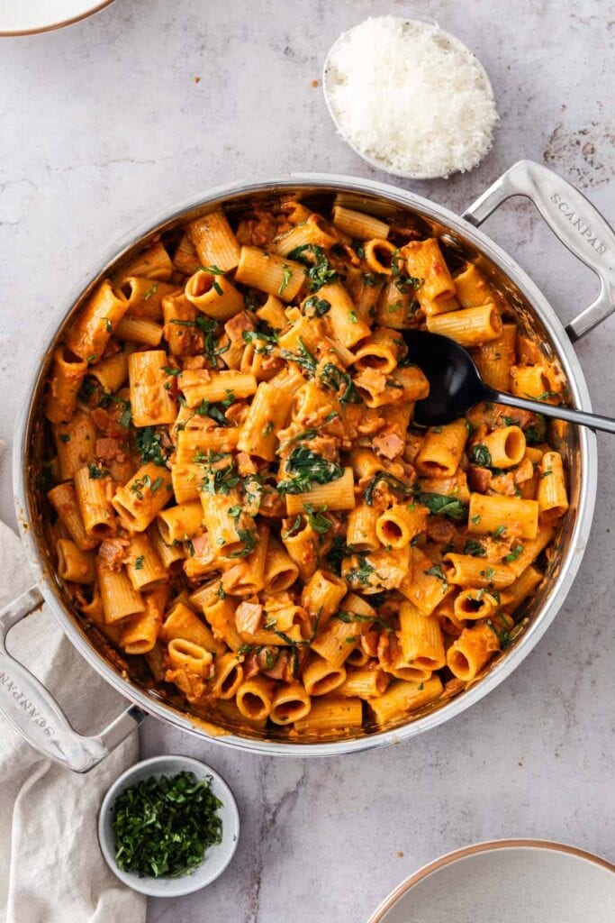 Creamy bacon and tomato pasta in a skillet.