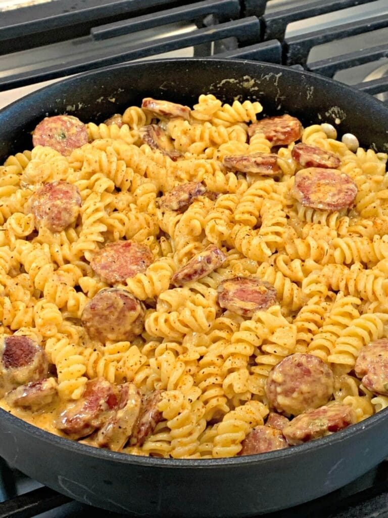 Creamy Cajun sausage pasta in a skillet.