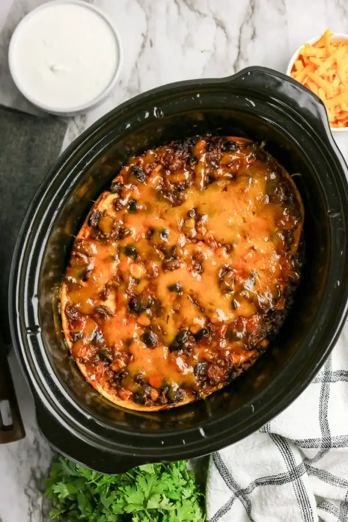 Overhead view of crockpot taco casserole with melted cheese.