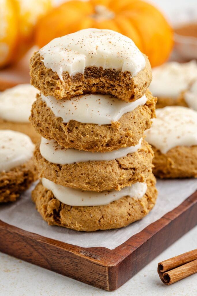 Close-up stack of frosted pumpkin cookies.