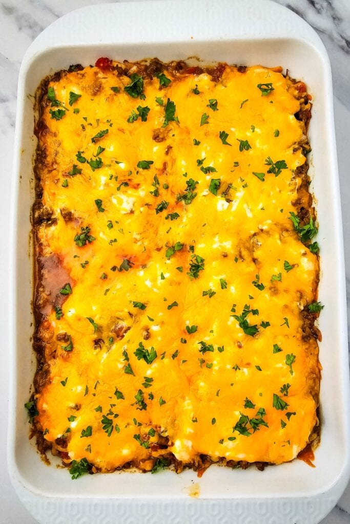 John Wayne Casserole topped with melted cheddar cheese and parsley.
