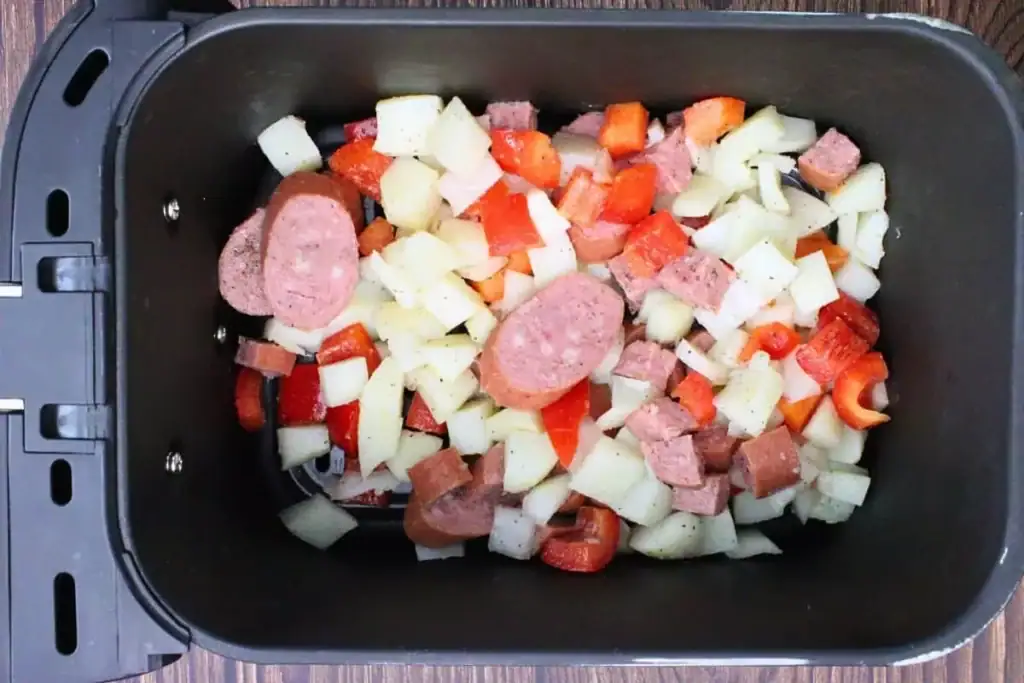 Kielbasa hash in an air fryer basket.