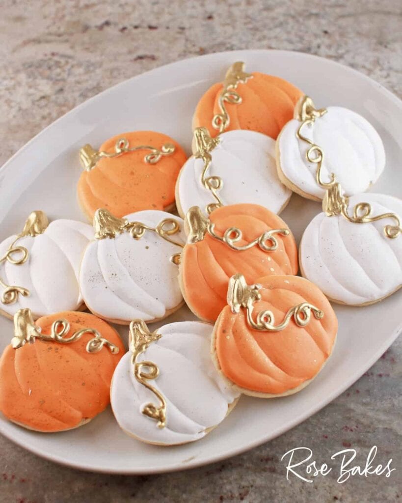 Pumpkin shaped sugar cookies on a plate.