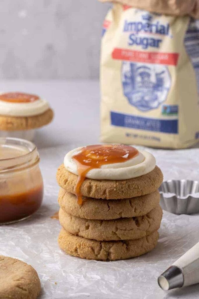 Stack of salted caramel cheesecake cookies on parchment paper.