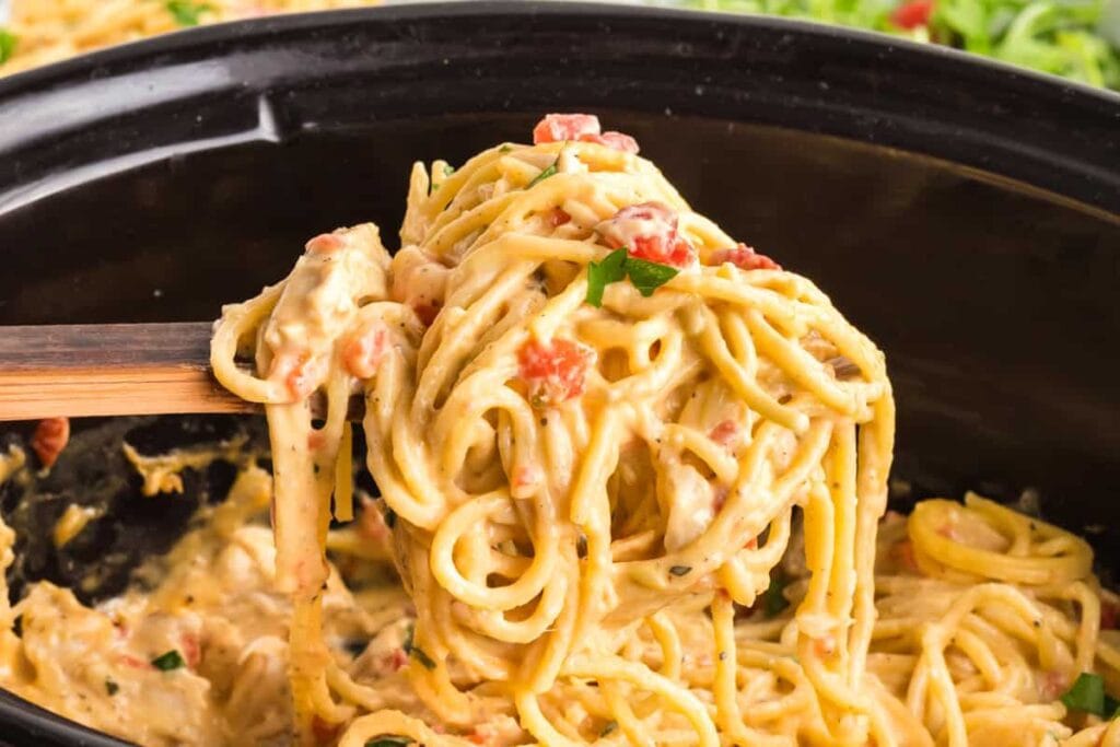 Close-up of slow cooker chicken spaghetti on a serving spoon.