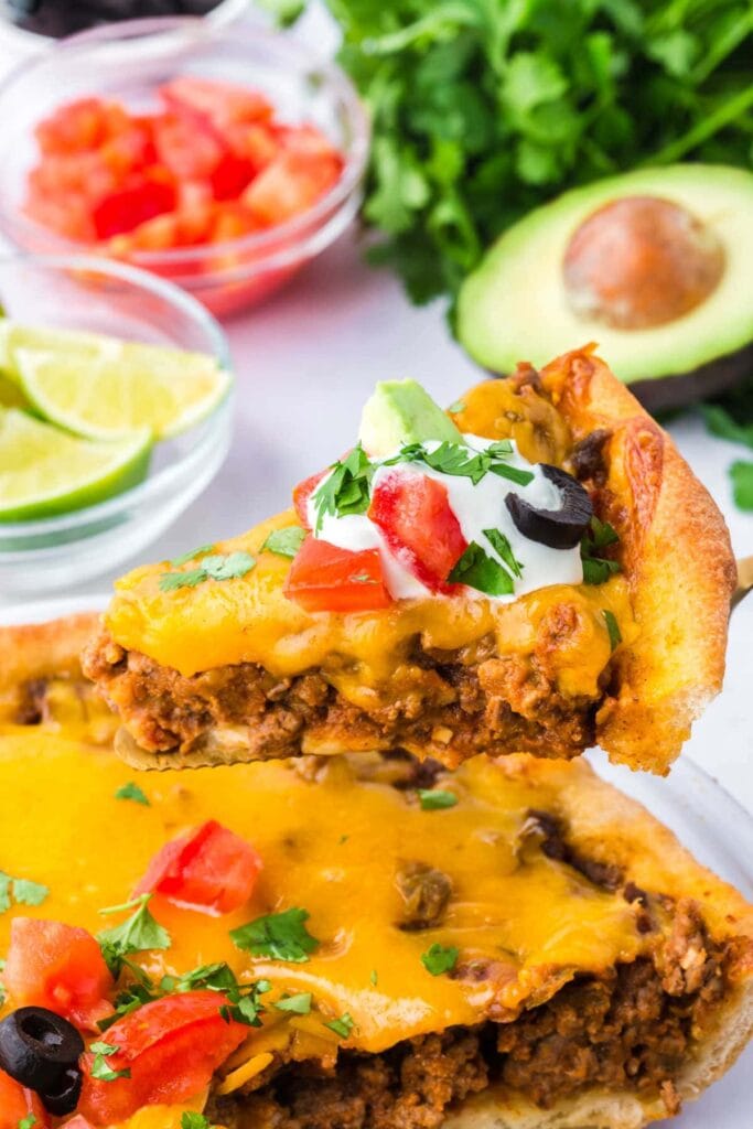Close-up of a taco pie slice on a spatula.