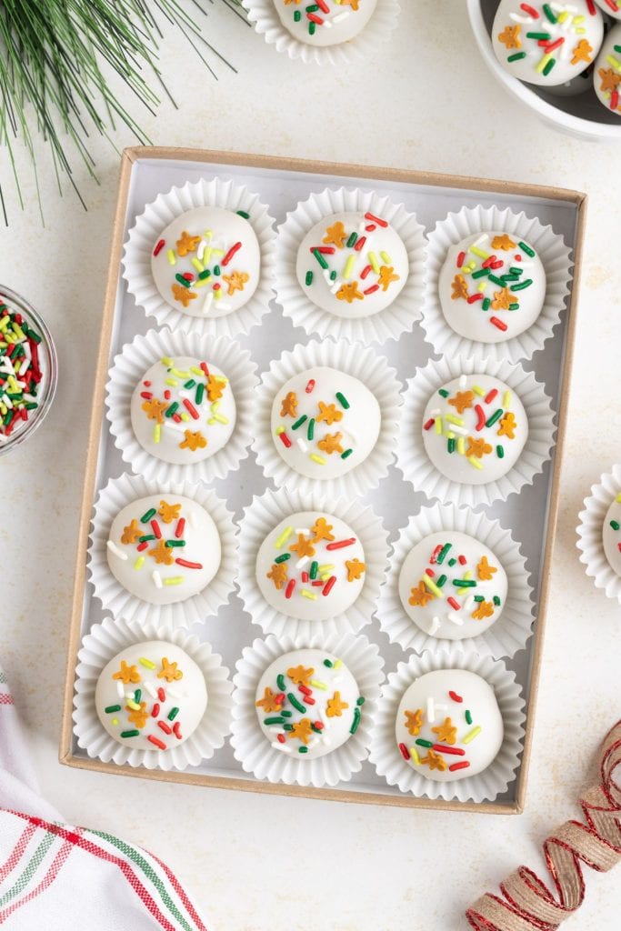 Gingerbread truffles coated in white chocolate with colorful sprinkles.
