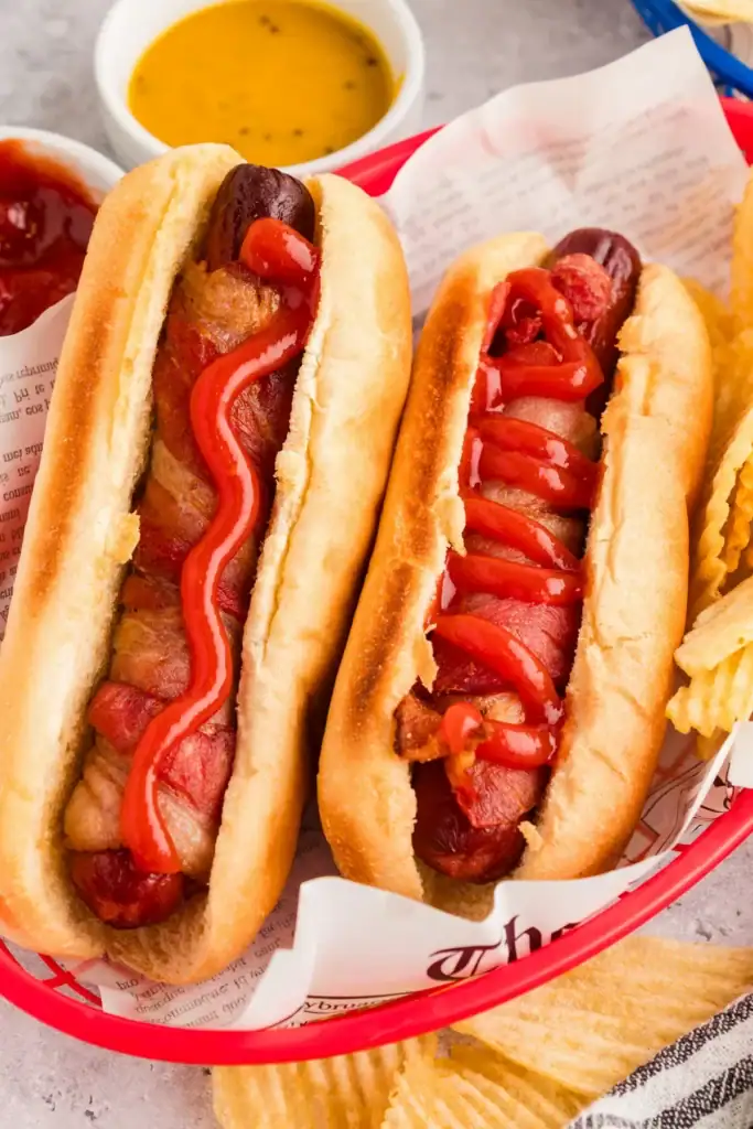 Two air fryer hot dogs in a serving basket.