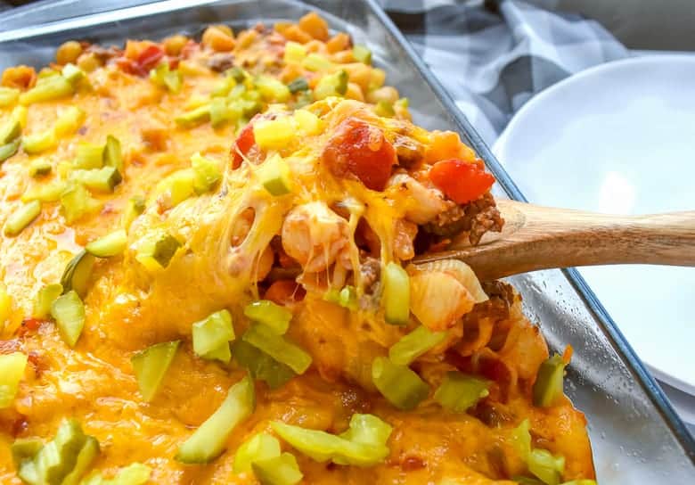 Cheeseburger casserole with a wooden spoon in the baking dish.