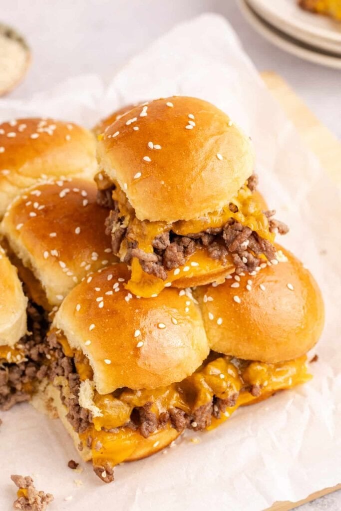 Cheeseburger sliders served on a wooden board.