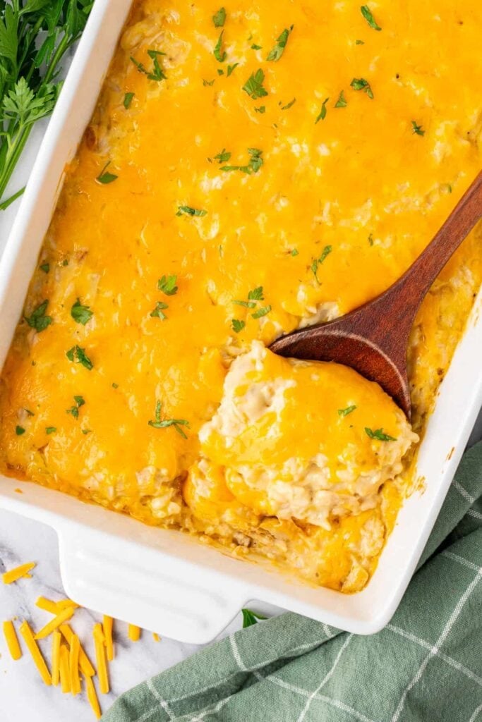 Chicken and rice casserole in a white baking dish with a serving spoon.