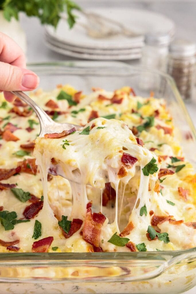 Chicken bacon ranch casserole in a baking dish with a serving spoon.