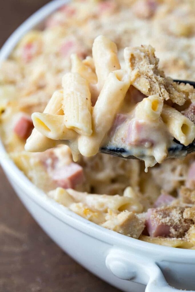 Close-up of creamy Chicken Cordon Bleu casserole on a serving spoon.