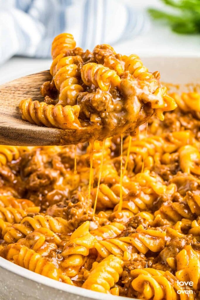 Close-up of enchilada pasta on a wooden spoon.