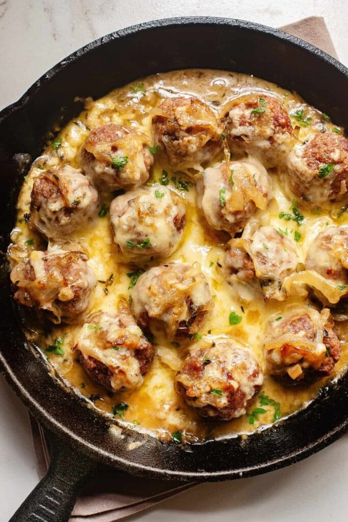 French onion meatballs in a skillet.
