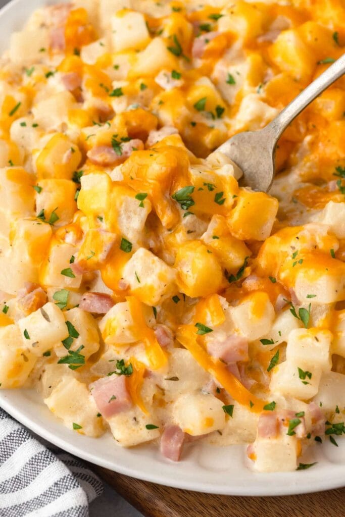 Close-up of ham and potato casserole with melted cheese.