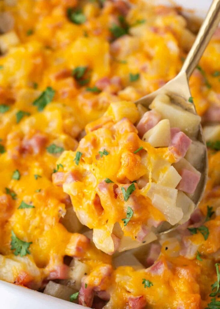 Close-up of ham and potato casserole on a spoon.