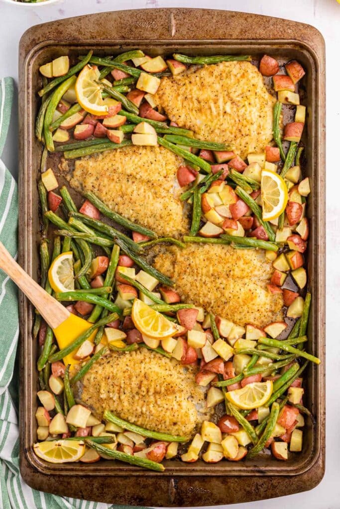 Lemon Pepper Sole Sheet Pan Dinner with lemon slices and roasted vegetables.