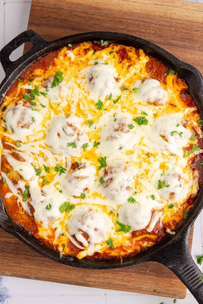 Meatball parmigiana in a cast iron skillet.