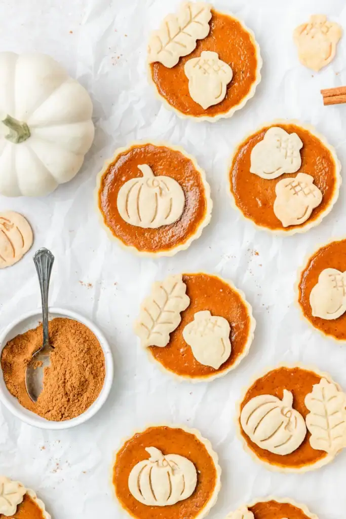 Mini pumpkin pie tarts on parchment paper.