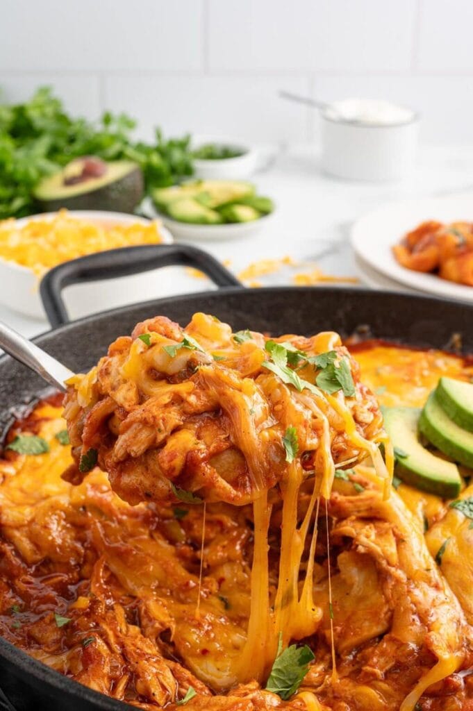 One Pan Enchiladas with melted cheese on a serving spoon