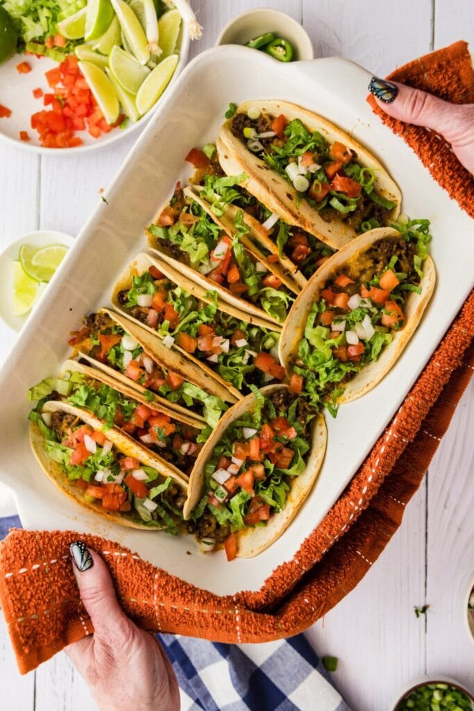 Overhead view of oven tacos arranged in a baking dish.