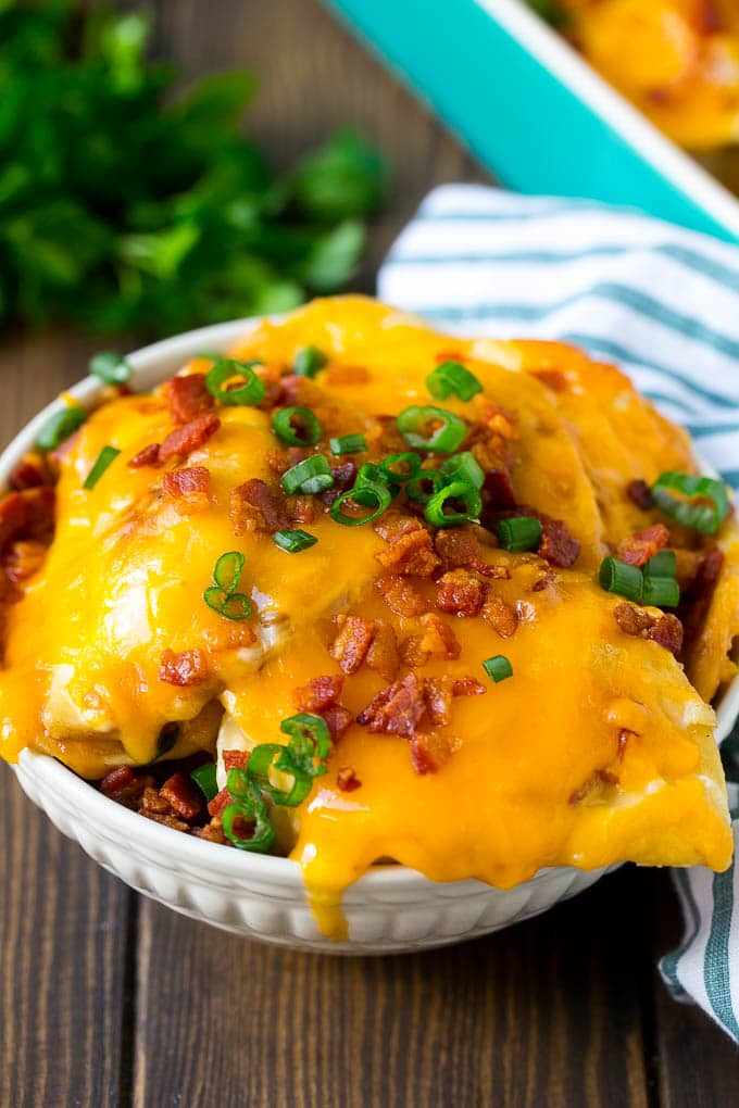 Pierogi casserole in a bowl with melted cheese and bacon.