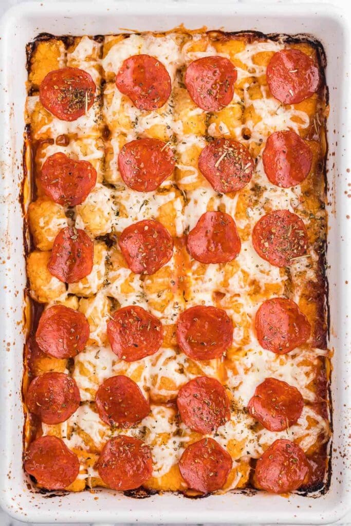 Pizza tater tot casserole in a baking dish with pepperoni and cheese.