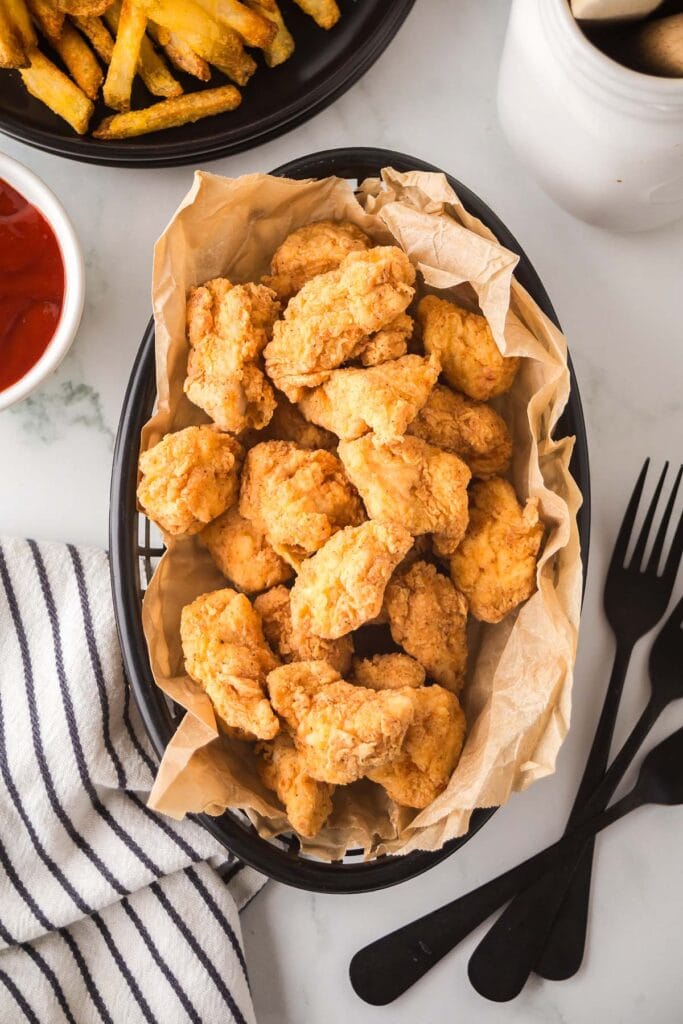 Popcorn Chicken in a basket lined with parchment paper.