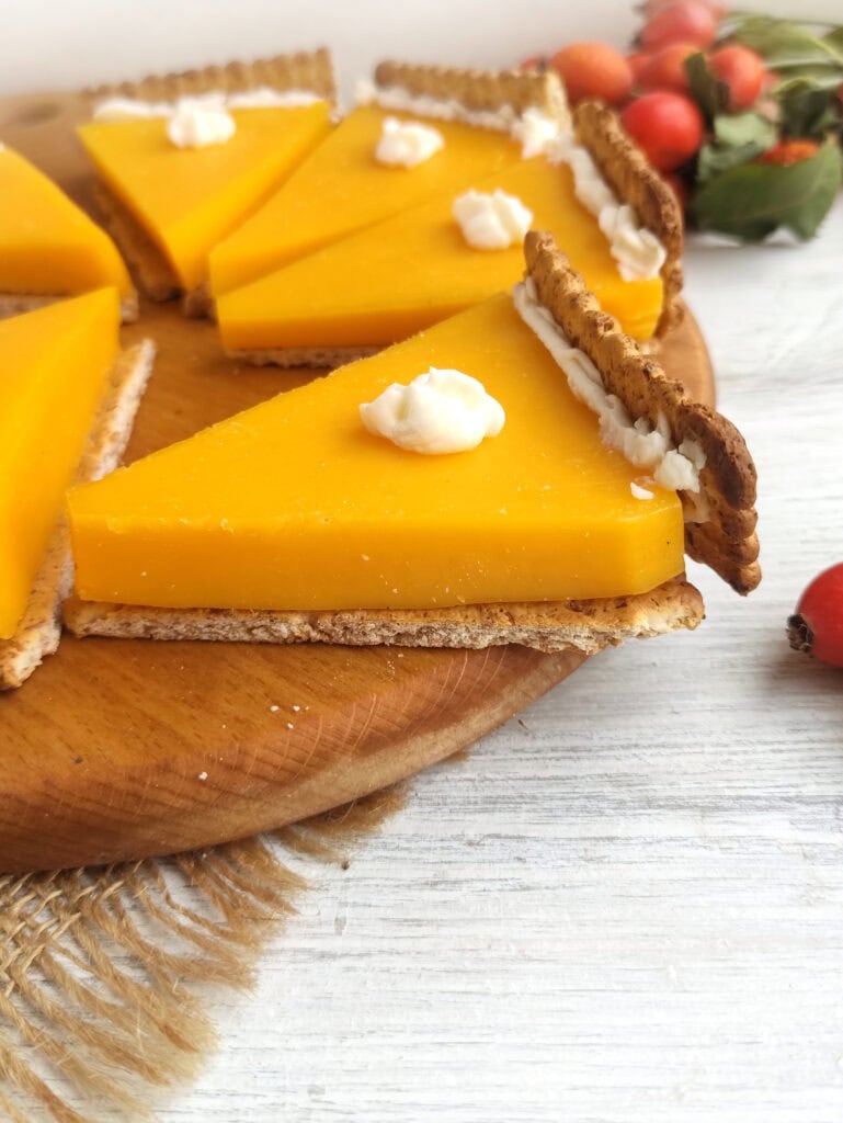 Close-up of pumpkin pie cheese and crackers on a wooden board.