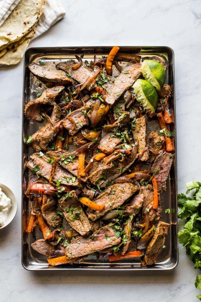 Steak fajitas on a sheet pan.