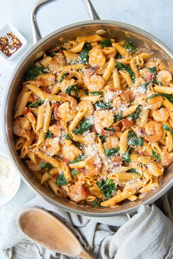 Shrimp and spinach pasta in a skillet.