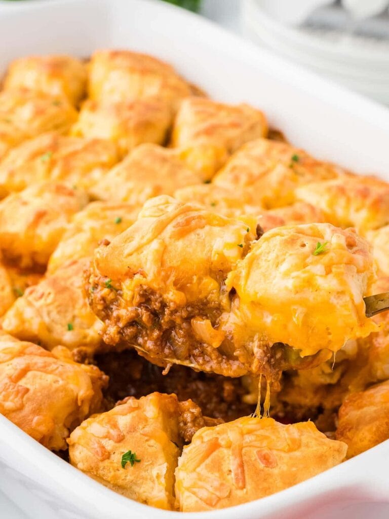 Sloppy Joe casserole in a baking dish with a serving being lifted.